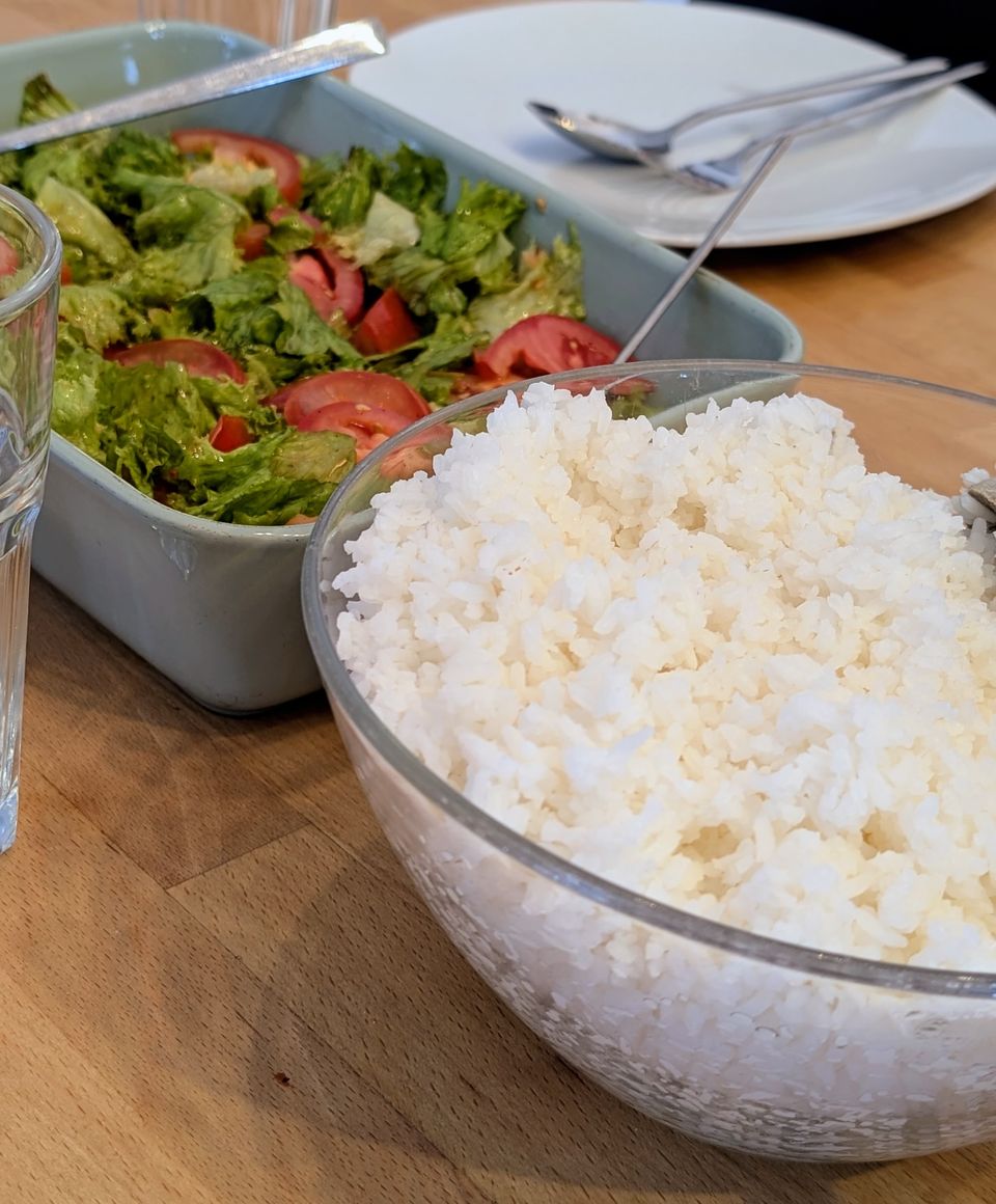 Schüssel mit duftendem Reis und frischem Salat